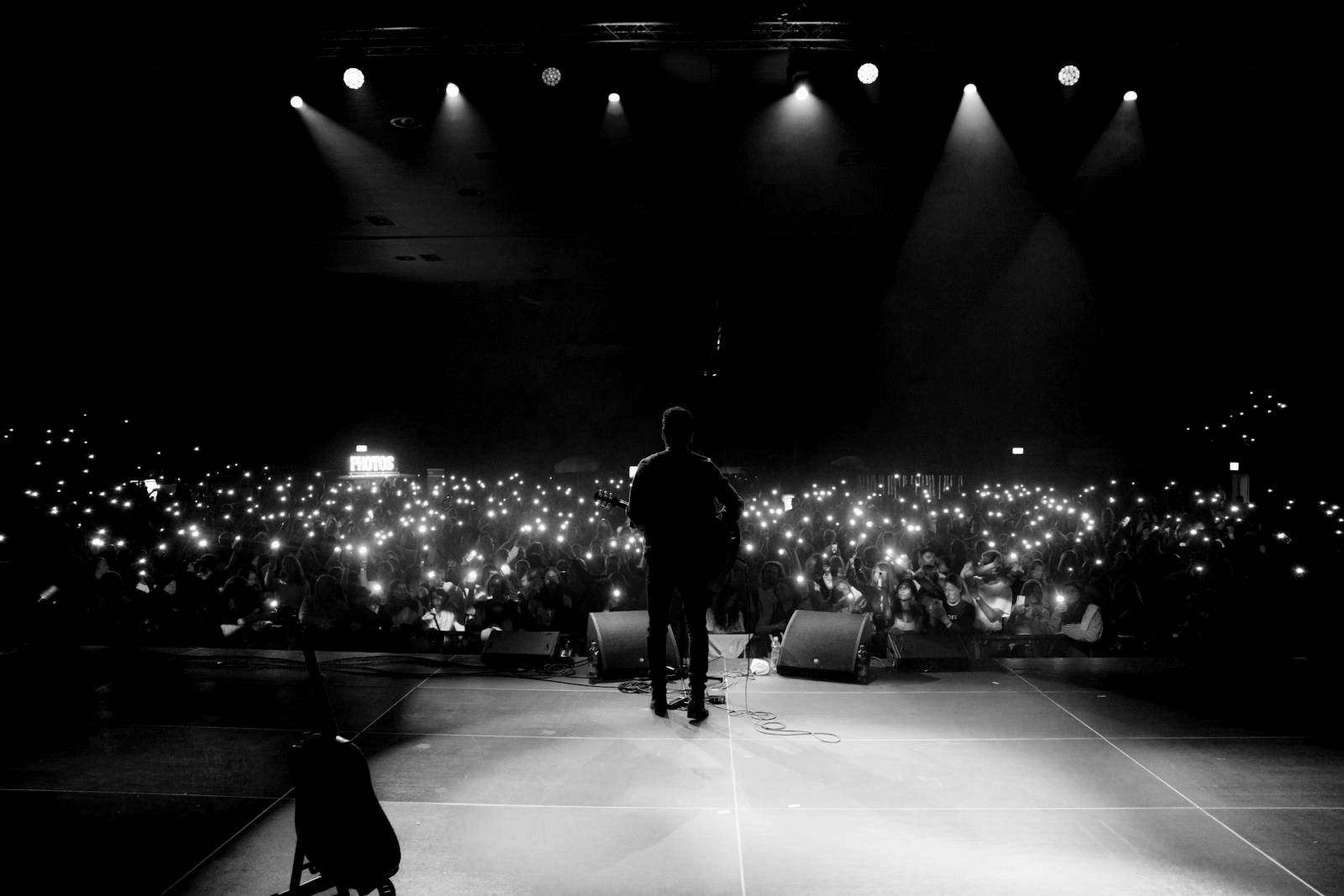 Blick von der Bühne in den vollen Saal am Nachteulen Festival, im Publikum leuchten Hunderte Handylichter.